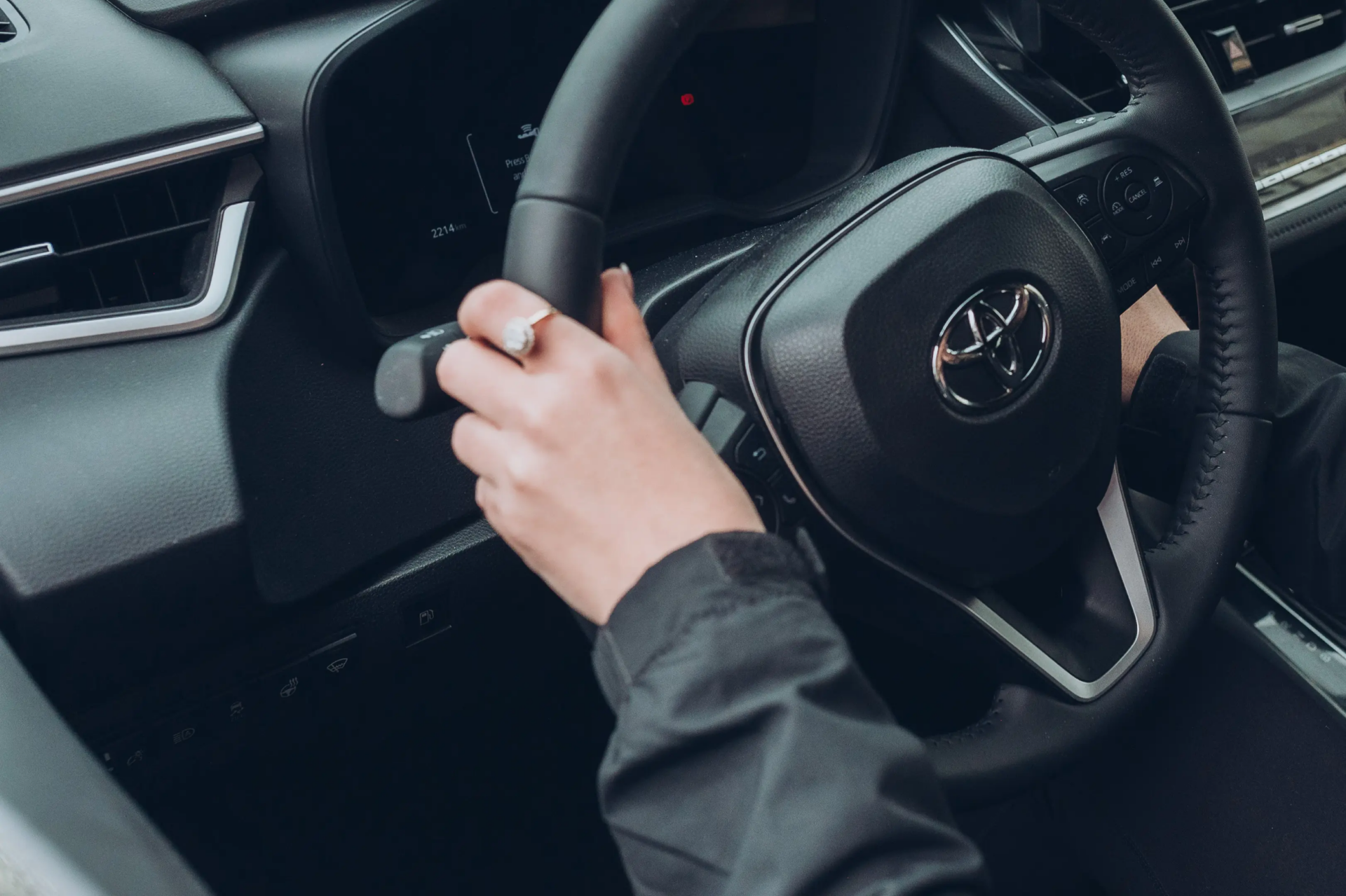Vehicle Checks for Winter Driving A person with a ring on their finger holds the steering wheel of a Toyota vehicle while preparing for winter driving.